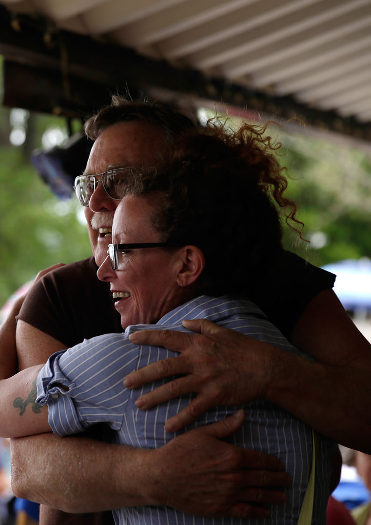 RoseAnn Gregory hugs Mike Cooper during Cooper's retirement party
